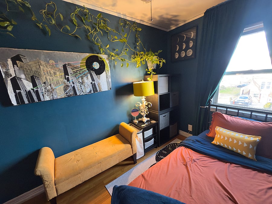 View of bedroom with storage bench, side table, shelving unit & lamp. The lights are color changing & dimmable and can be adjusted to your preference with a free mobile app on your phone.