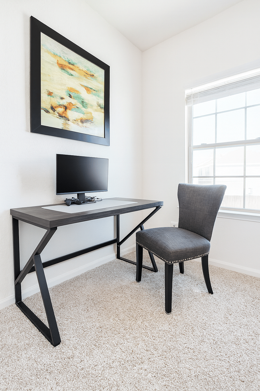 This dedicated workspace features a desk and chair for work or play, a monitor, fast WiFi, and ample desk space with good lighting. The space is ideal for remote workers, offering a comfortable and productive environment.