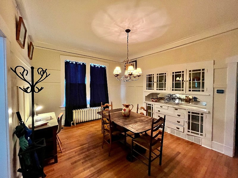 Spacious dining room features a gorgeous Craftsman built in buffet and real wood furniture. There is also a small desk and lamp. A game closet and folk art make this the heart of the home.