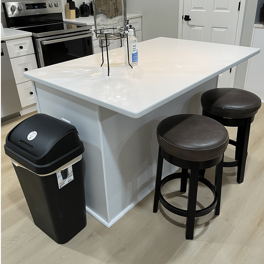 Island between the kitchen and living room with 2 barstools