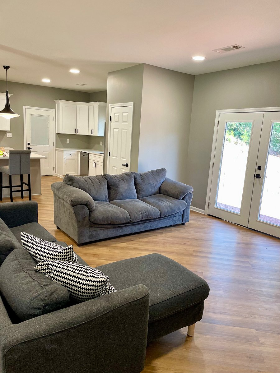 Den leads out to back porch through French doors