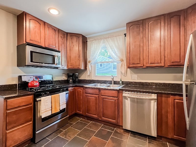 Full kitchen with gas burner, coffee pot, Keurig, microwave, dishwasher, and oven