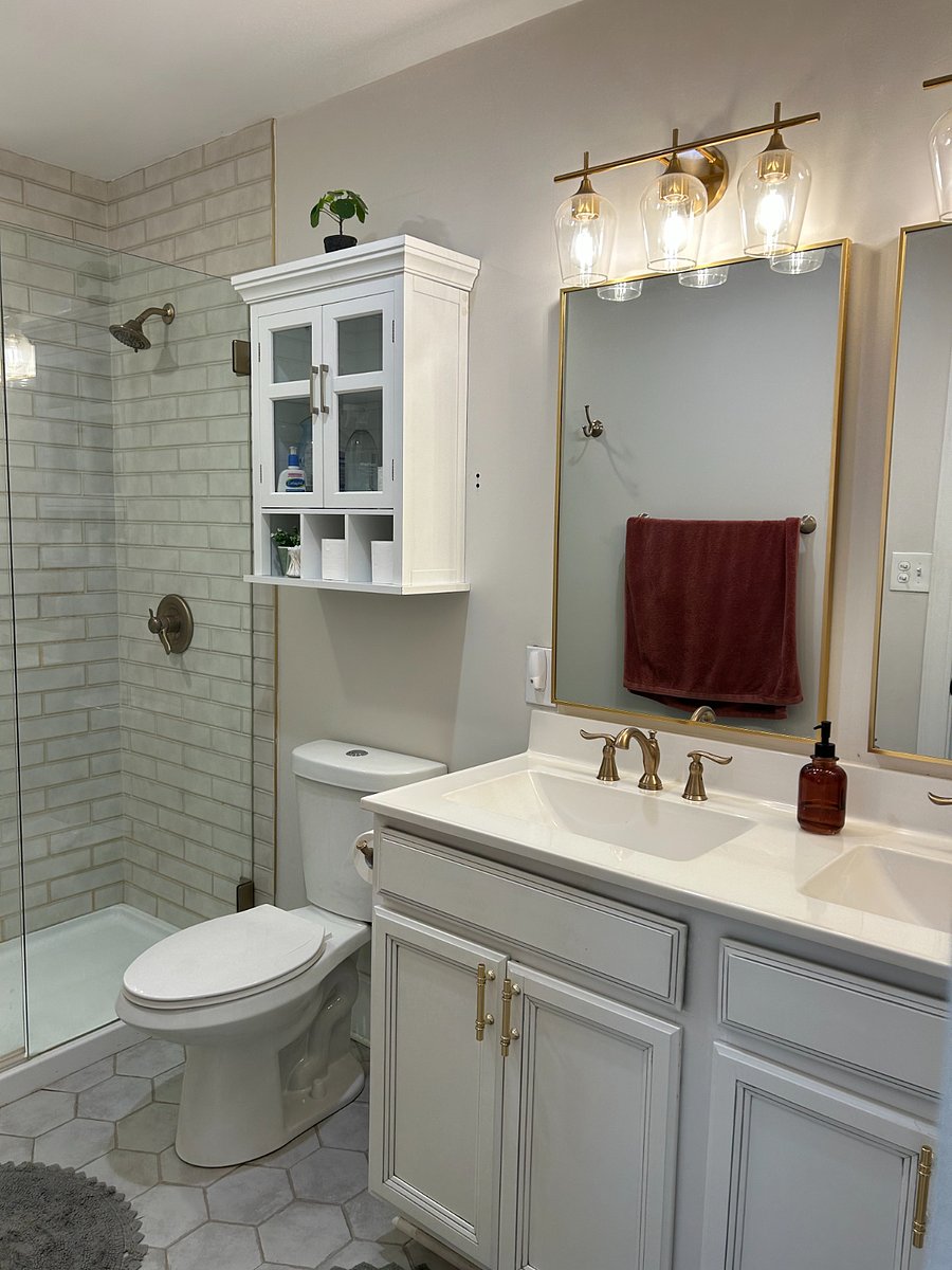Shared bathroom with double vanity and tile shower