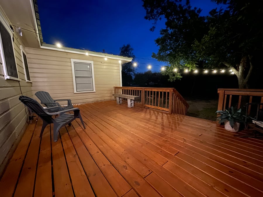 Backyard deck with string lighting is great for relaxing after a long day!