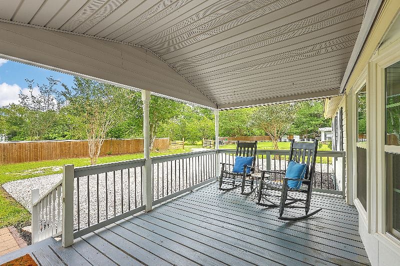 Front porch and large driveway for multiple cars. 