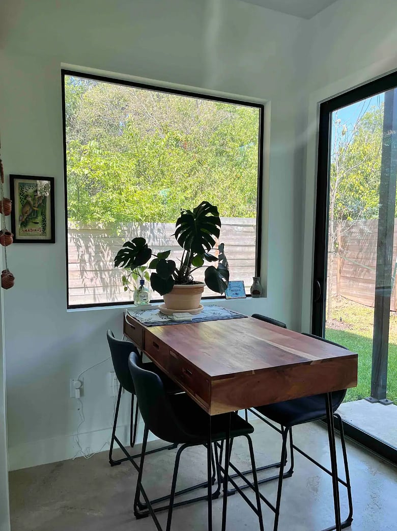 Dining area with seating for four, offering a spacious window view.