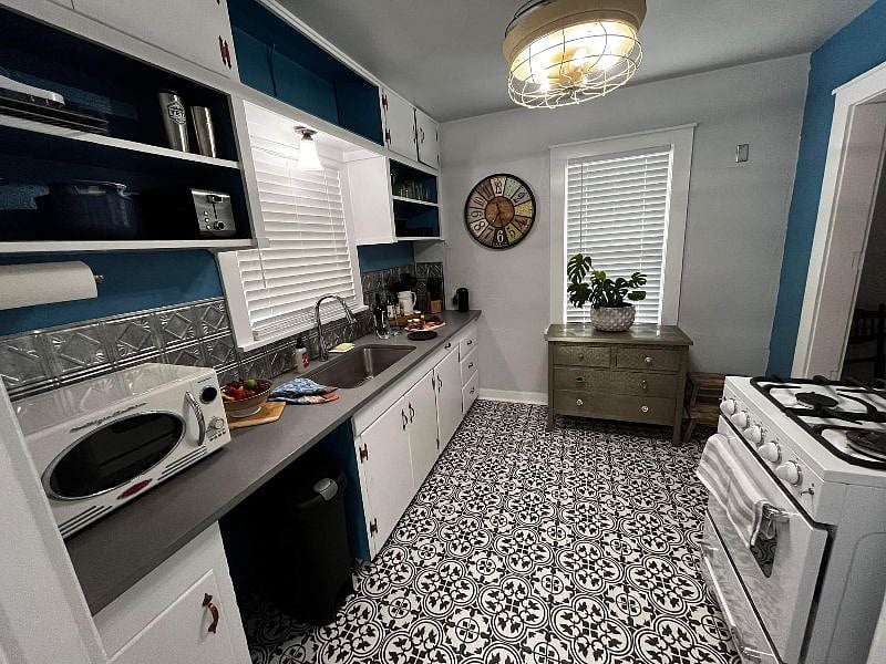 kitchen with quartz countertop,  apartment sized gas range and oven, fridge and freezer 