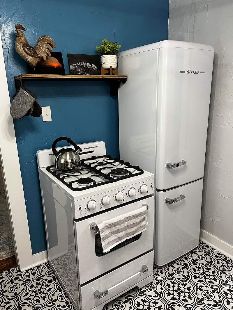 kitchen with quartz countertop,  apartment sized gas range and oven, fridge and freezer 