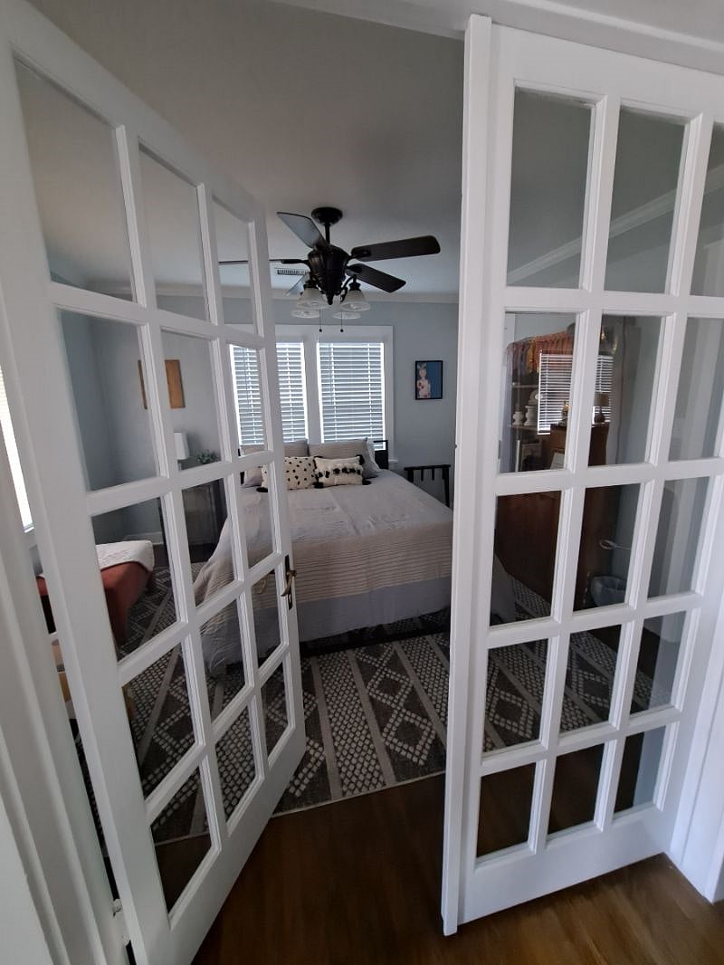 bedroom #1 at front of house with large window, black out curtains and blinds 