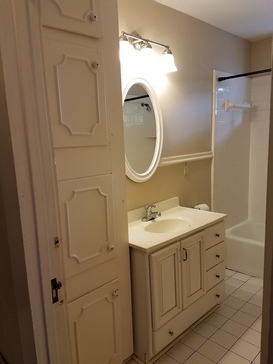 Bathroom, tub/shower combo, vanity for storage, floor to ceiling cabinet for storage.