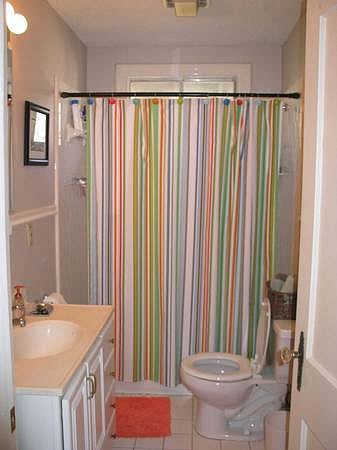Bathroom, tub/shower combo, vanity for storage, floor to ceiling cabinet for storage.