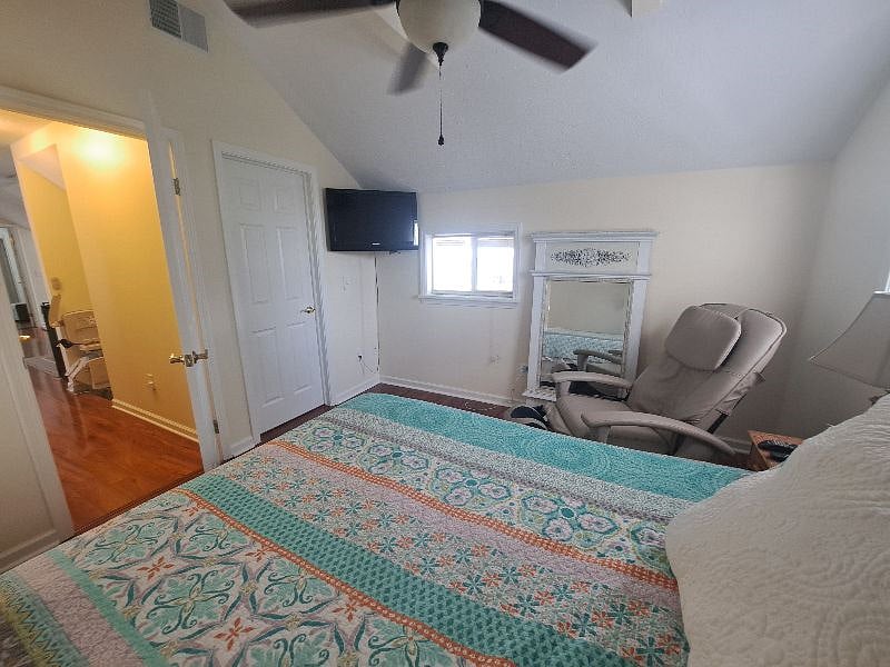 Master bedroom with massage chair, smart tv and walk in closet