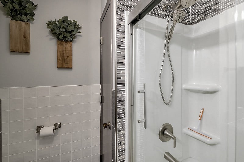 Bath and shower with upgraded Moen Shower with magnetic hand held shower head. -bath closet has a large shelf for each bedroom labeled.