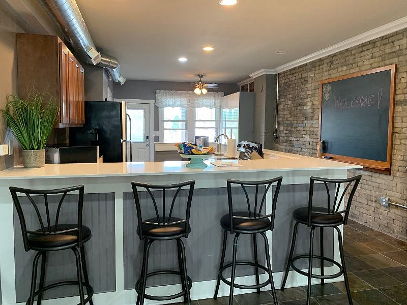 View of the kitchen from the dining table. The door in the picture is the entry door from the porch. Breakfast bar doubles as a workspace for your laptop or tablet.