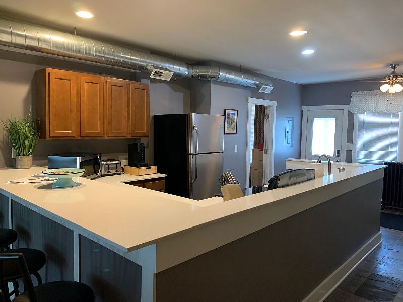 Lots of quartz countertop space for prepping meals, eating, and gathering.
Open doorway is entrance into the primary bedroom.