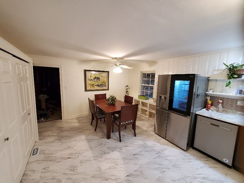 Large dining table opposite the open kitchen floorplan.