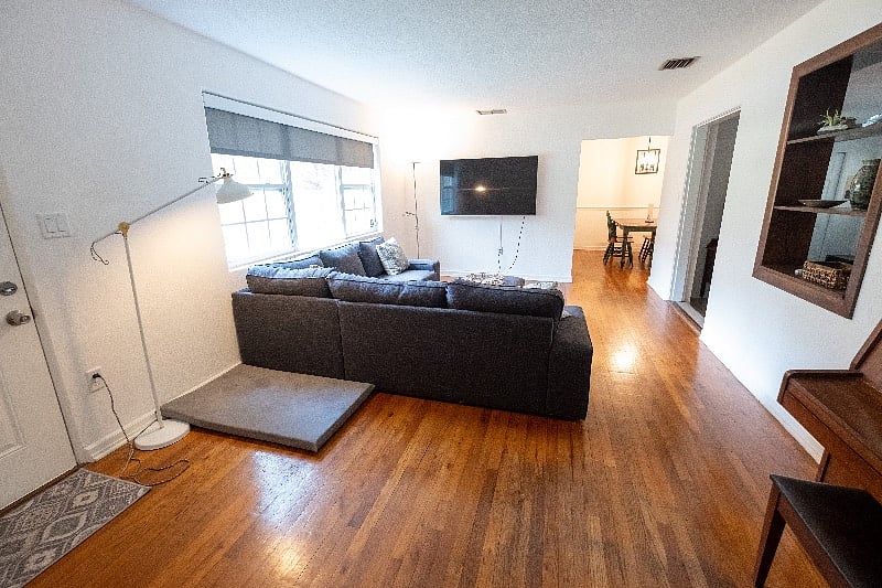 Shared family room with 65" TV and comfy couch and blankets.