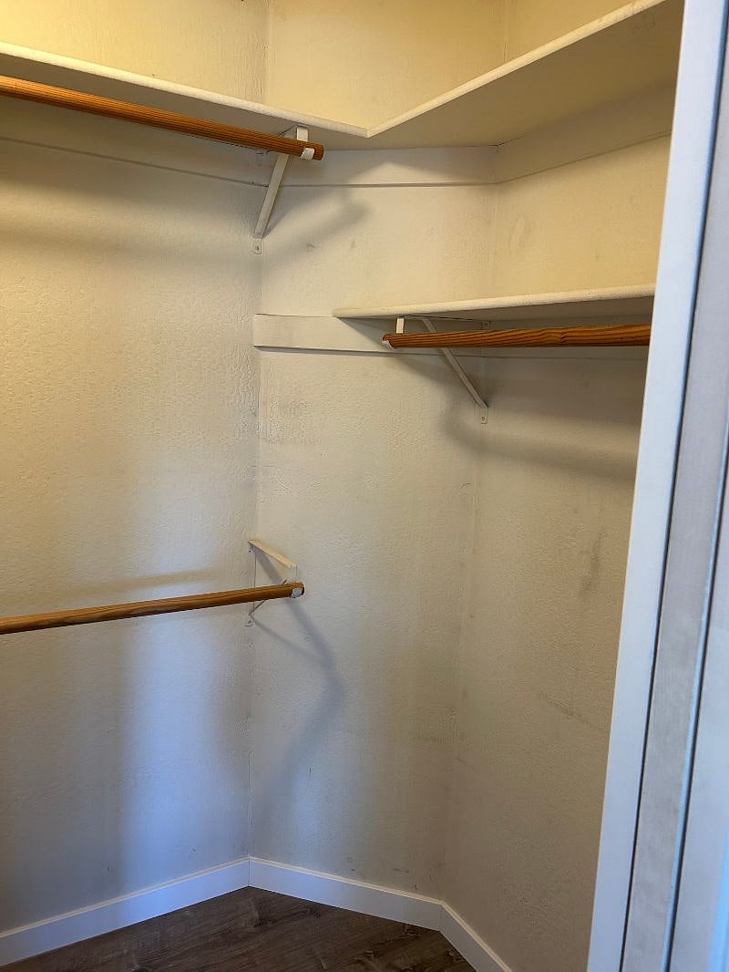 Large walk in closet with multilevel hanging rods and shelving 