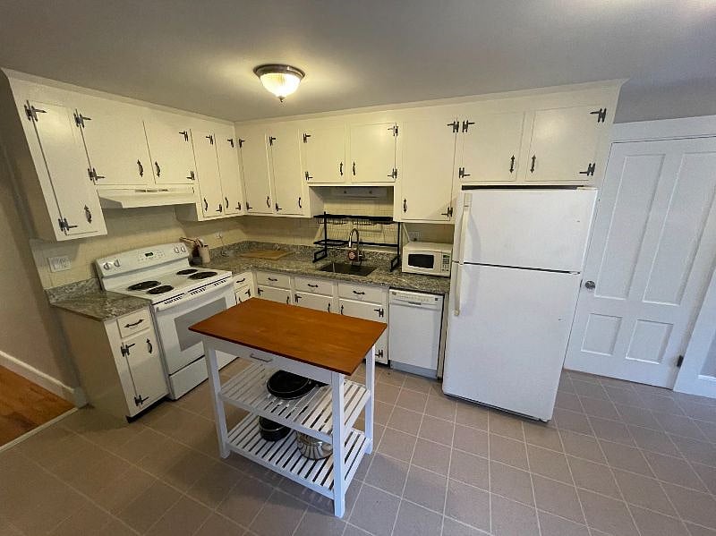Kitchen with granite counters, dish washer, microwave, stove/oven, and refrigerator.
