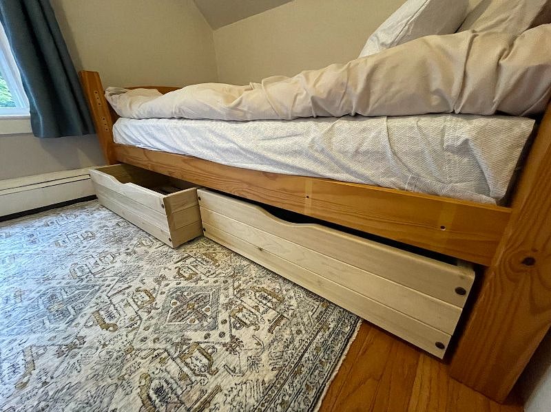 Bedroom with twin bed has 2 large drawers under the bed