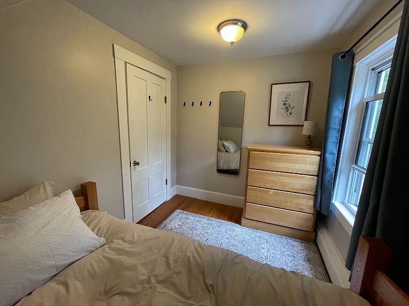 Bedroom with twin size bed. (Smaller of the 2 bedrooms) Comes with dresser, mirror, and hooks, and night stand.