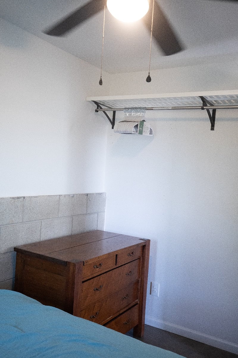 Private bedroom with solid wood dresser and hangers