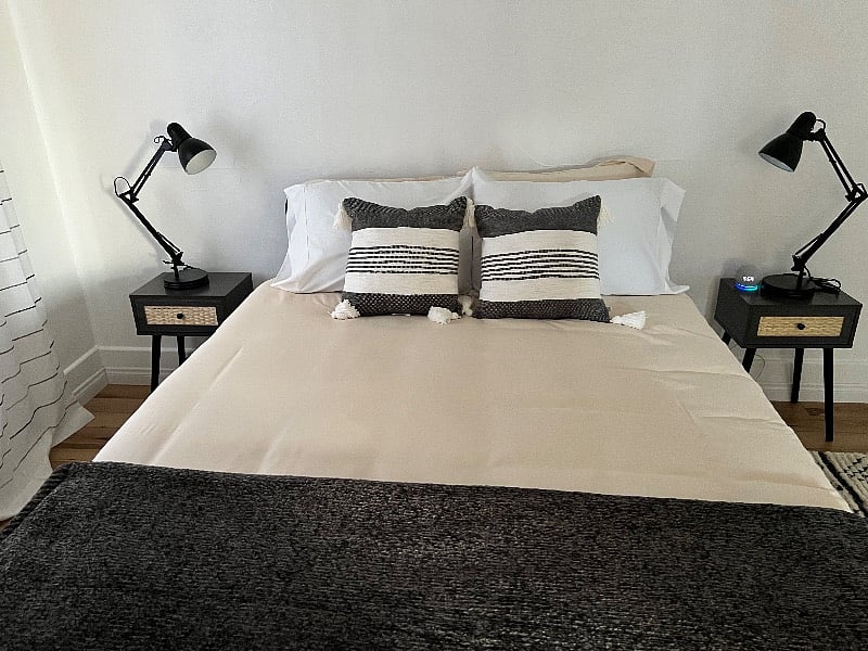 Queen size bed in second bedroom with nightstands and lamps on each side.