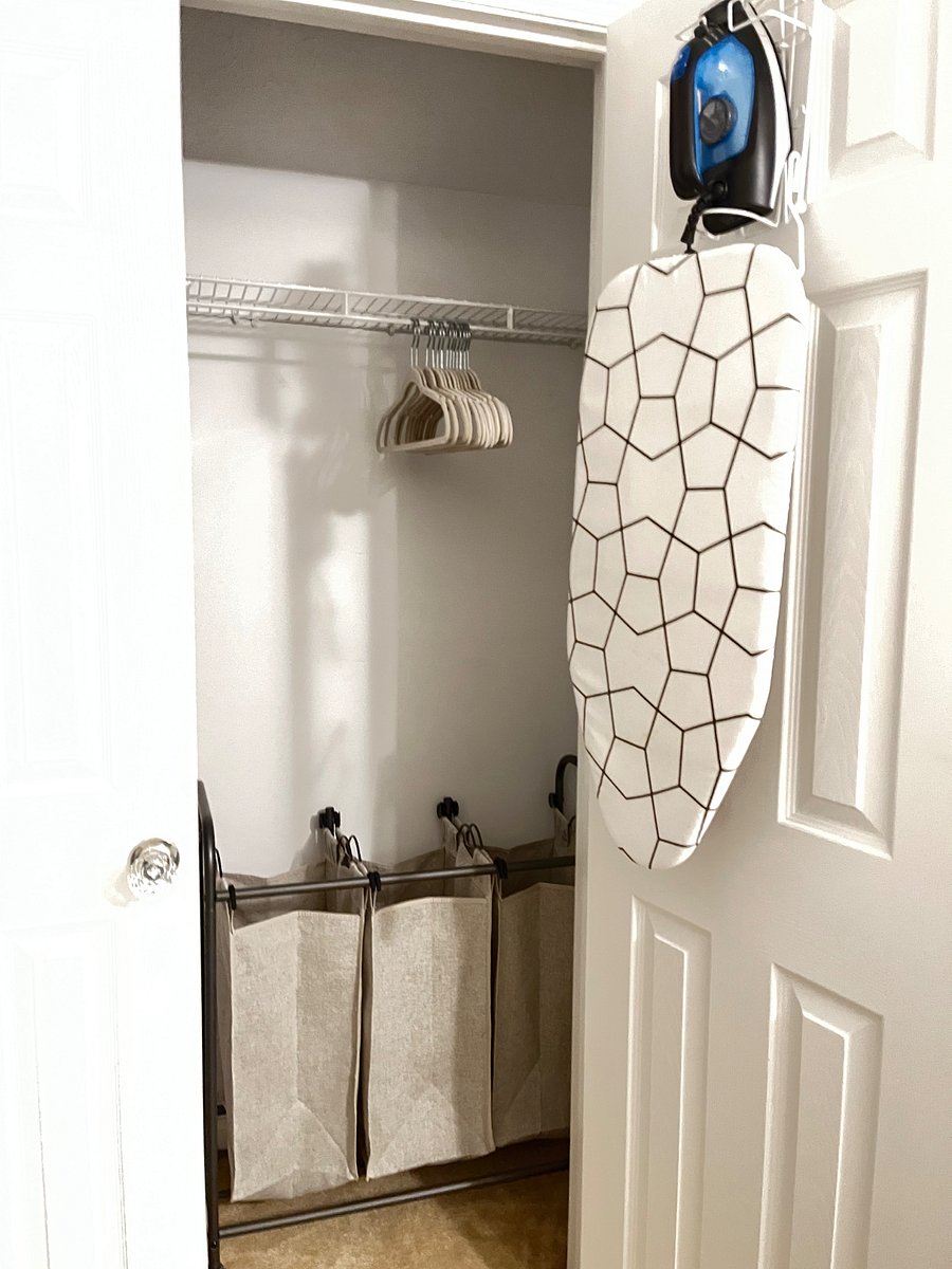 Closet with velvet hangers, top shelf storage space, Iron and Ironing board, and roll out hamper for dirty clothes and linen