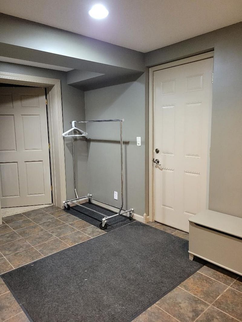 Bedroom door on the left, extra coat hanging space and door to the garage which will be your main entrance in and out of your living space.