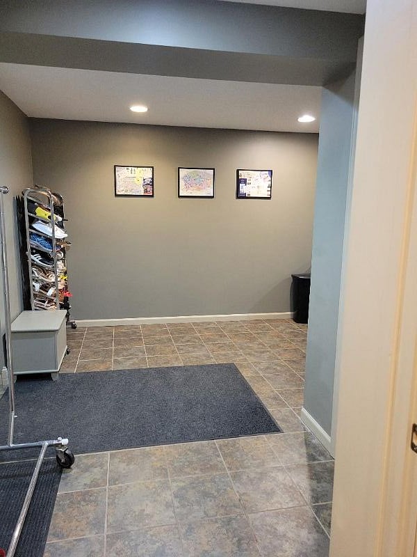 Looking outside of the bedroom, garage door on the left, hallway wraps to right towards the kitchenette set up.