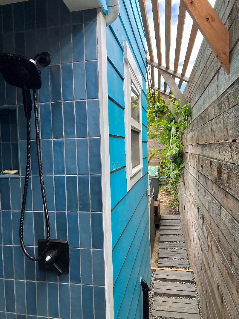 Indoor outdoor shower; paved path leading to hot tub/deck/garden