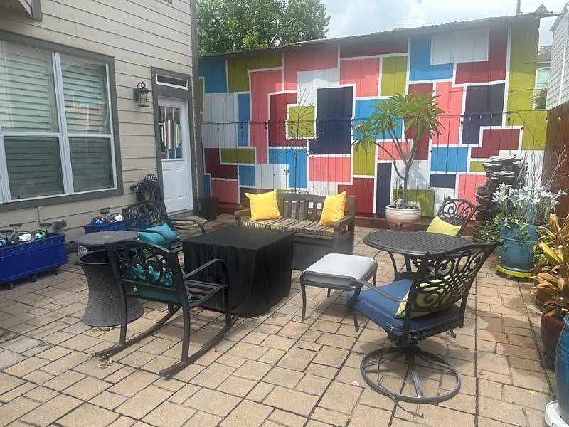 Peaceful private patio with comfortable seating, a fountain, and a gas fire pit, creating a relaxing outdoor space to unwind or enjoy Houstons mild weather. The patio also includes outdoor dining and lounge seating, making it perfect for morning coffee, evening meals, or simply relaxing outside.