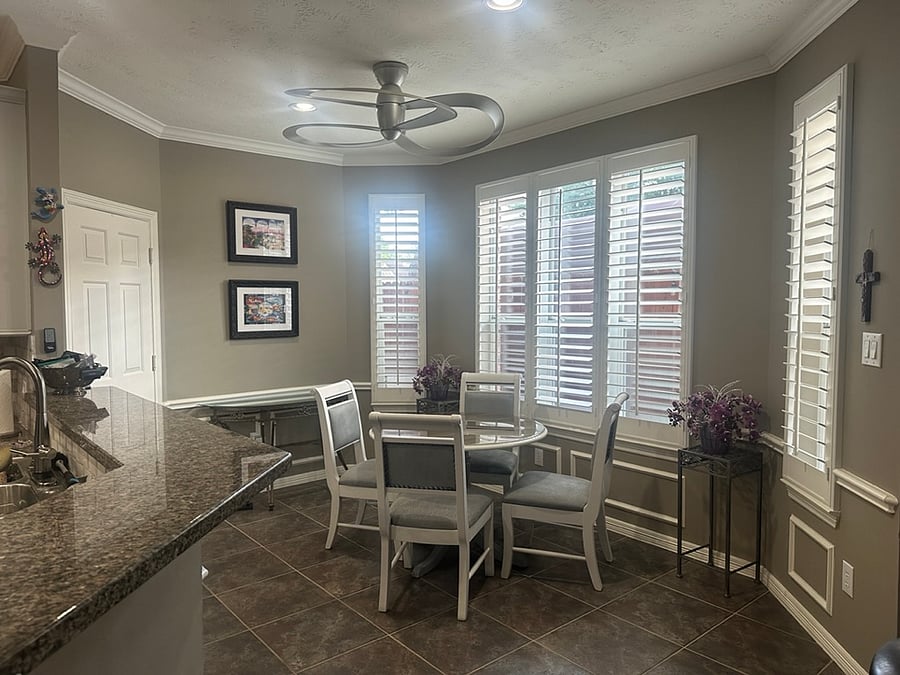 Sunny breakfast area with large windows and plantation shutters, providing plenty of natural light while maintaining privacy. A comfortable spot for coffee, casual meals, or working during the day.
