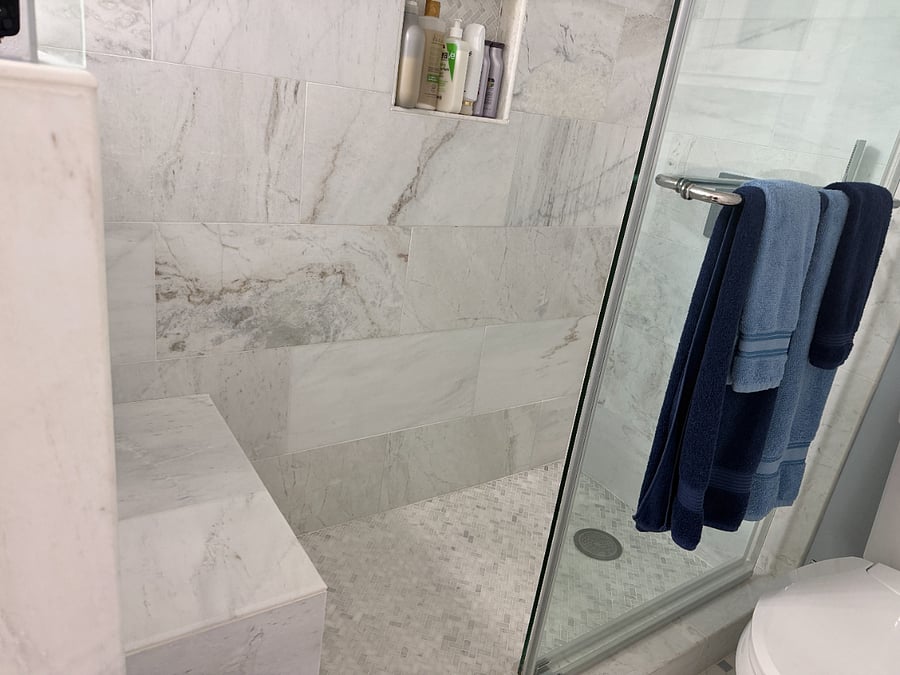 Contemporary double vanity with vessel sinks and illuminated mirror, offering ample counter space and stylish lighting. The updated cabinetry and modern fixtures complement the bright, clean design of this newly renovated private bathroom.