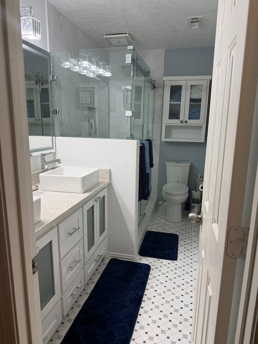 Bright, newly renovated bathroom featuring a spacious double vanity with vessel sinks, modern fixtures, and a lighted mirror that provides excellent lighting for daily routines. The layout includes a glass-enclosed shower and a bidet toilet seat for added comfort and convenience, along with ample storage to create a clean and comfortable private bathroom