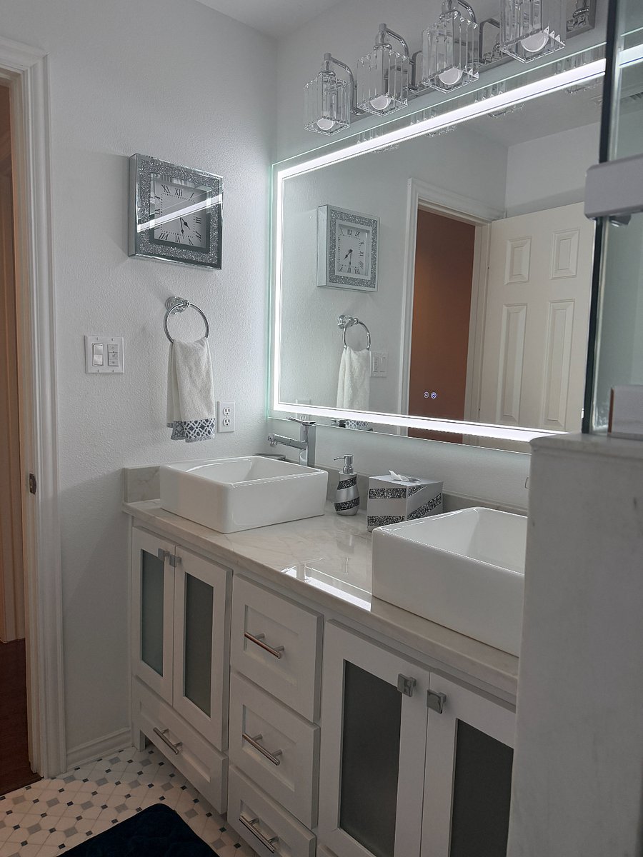 Elegant custom walk-in shower with marble tile, glass enclosure, waterfall rain shower head, and a built-in bench seat for added comfort. A recessed niche provides convenient storage for toiletries.