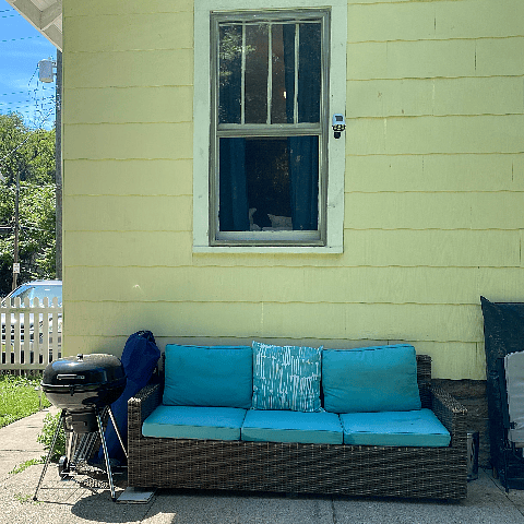 Charcoal grill and a cozy couch for outdoor relaxing. Corn hole set included!