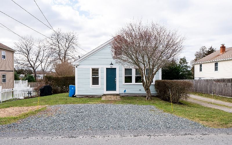 Winter photo of the exterior of the cottage with parking in the front