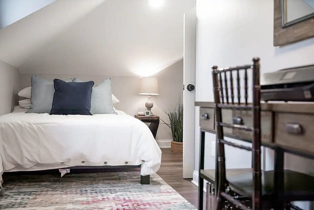 The bedroom sits off the bathroom and living room. The ceilings are low at the head of the bed.