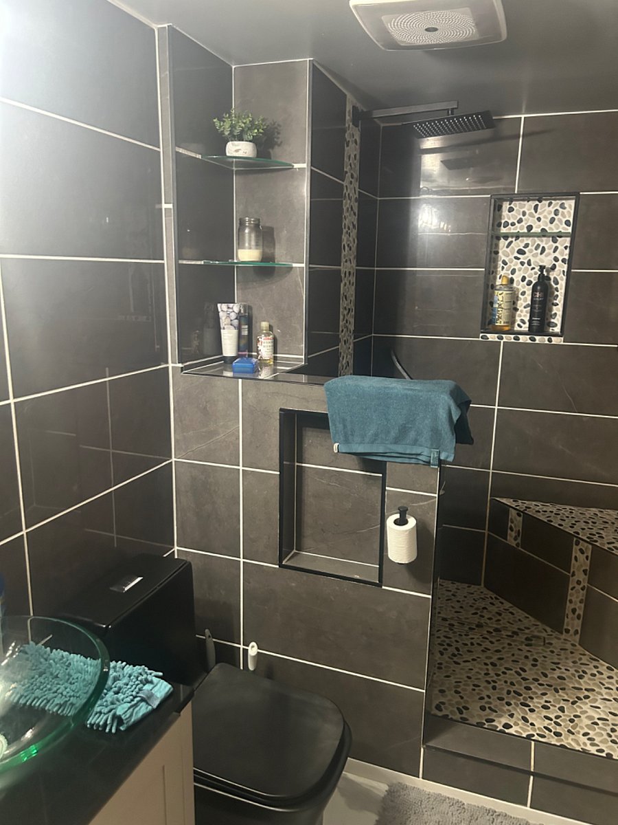 Take a nice warm shower in this state of the art bathroom with shower wand & sitting shower area .