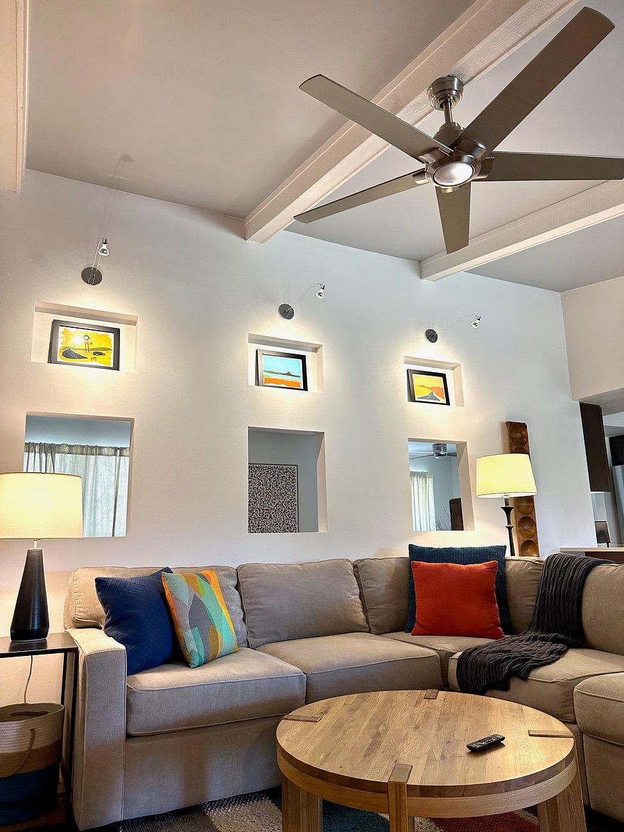 Livingroom has vaulted ceiling, large ceiling fan, and designer lighting