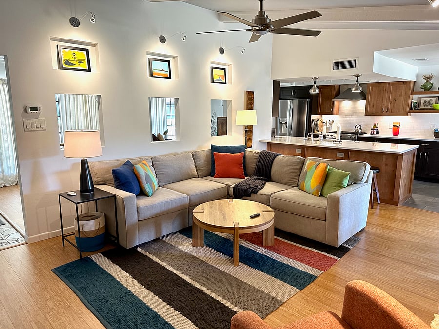 Livingroom features vaulted ceiling, designer lighting, and comfy furnishings, plus large capacity ceiling fan