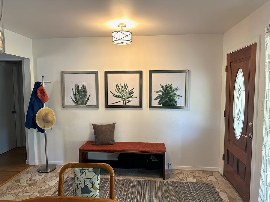 Entry area features coat tree, bench, and storage shelf