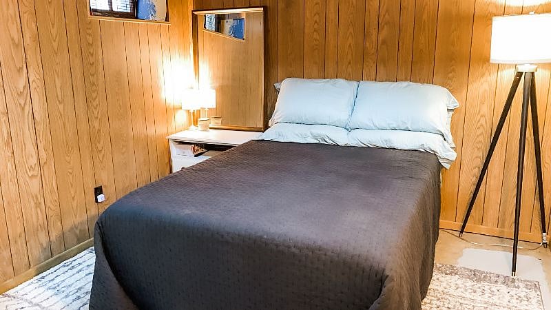 Basement bedroom with double bed and workspace