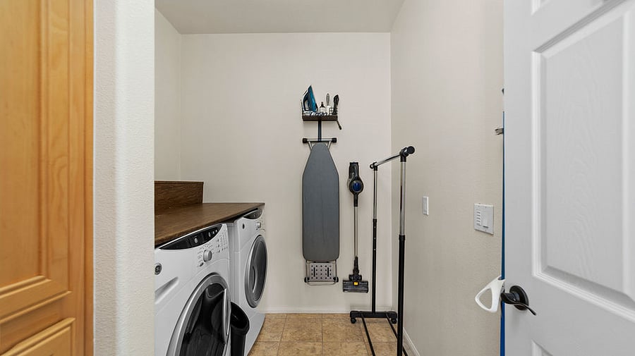 Laundry room with full size cabinet, Iron + Ironing board, and rack for hang drying.