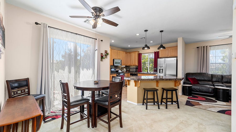 Dining and upper balcony access through sliding glass door.  Bar height table with 4 chairs and additional seating at kitchen island.