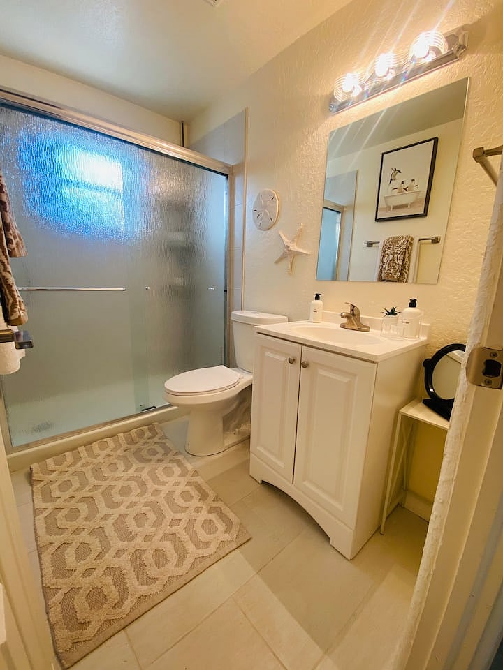 Newly remodeled bathroom with rain showerhead and plenty of linen storage.