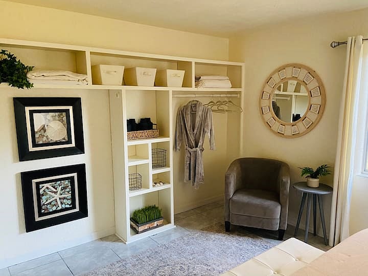 Primary bedroom's clothing area with plenty of shelf storage and a nice sitting area for your morning coffee.