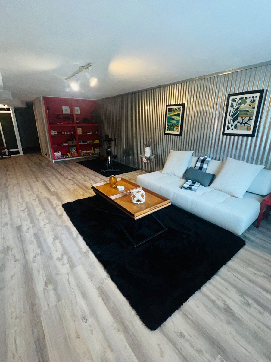 Living room featuring stocked gaming shelf and exercise equipment 