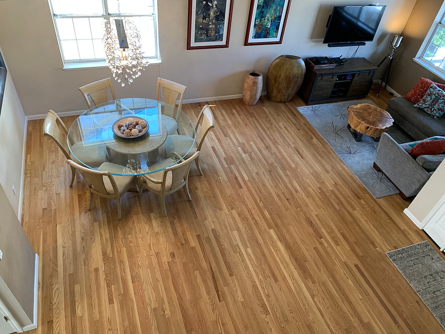 View from top of stairs down onto the family room/dining room. The white oak hardwood floors were recently refurbished to bring back their original beauty.